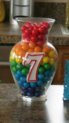 a vase filled with lots of candy and a number seven on it's side