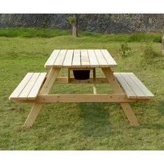 a picnic table with two benches in the grass