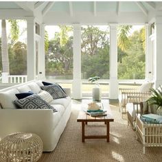 a living room filled with white furniture and lots of windows on top of each other