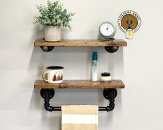 two wooden shelves with towels and other items on them next to a potted plant