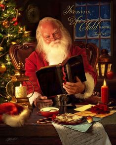 a man sitting at a table with a book in front of him and a christmas tree behind him