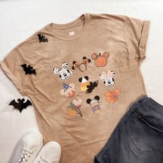 Fall Disney Character Print Tops, Disney Character Print Tops For Fall, Disney Halloween Cotton T-shirt, Character Print Top For Disney Fan Events In Fall, Disney Fan Merchandise T-shirt For Fall, Disney T-shirt With Cartoon Print For Fall, Disney Character Print T-shirt For Fall, Graphic Print T-shirt For Disney Fan Events In Fall, Fun Tops For Disney Fan Events In Fall