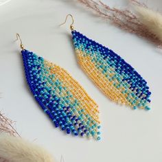 These long beaded earrings feature a vertical gradient transitioning from blue to yellow hues. Handmade with meticulous attention to detail, they exude sophistication and elegance. Perfect for completing your ensemble with chic and style. Dimensions: - Length: 10 cm (3.9 inches) - Width: 3 cm (1.2 inches) Blue Tassel Earrings For Festivals, Blue Tassel Drop Earrings For Festival, Bohemian Blue Long Drop Beaded Earrings, Adjustable Blue Tassel Earrings With Colorful Beads, Blue Bohemian Beaded Chain Earrings, Blue Dangle Chandelier Earrings For Festival, Festival Blue Chandelier Earrings With Colorful Beads, Blue Bohemian Chandelier Earrings For Festival, Multicolor Long Drop Tassel Earrings With Dangling Beads