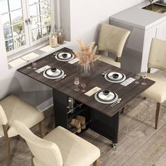 a dining room table with four chairs and plates on the placemats in front of it