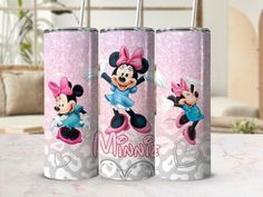 three mickey and minnie mouse canisters sitting on a table with a pink background