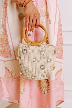 - Elevate your OOTD with this whimsical bucket bag! Its sweet woven design and glamorous rhinestone accents come together for charming luxe style. - All natural woven material with wooden accent material - Shimmering rhinestone embellishment - Gold colored hardware - An open top fully lined pouch with drawstring closure - Two natural rattan woven handles - Due to the natural raw material of our product. Each item may vary in color and size. Pink Games, Short One Piece, Luxe Style, Blue Springs, Woven Design, Black Dresses Casual, Little White Dresses, Crop Top Blouse, Gold Collection