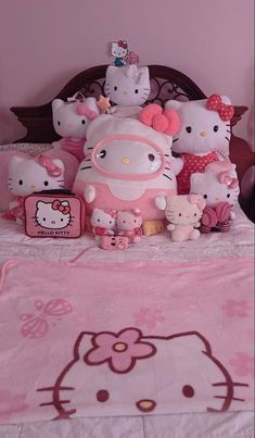 a bed with hello kitty and other stuffed animals on it