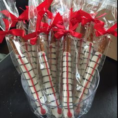 some cookies wrapped in plastic and tied with red ribbon are sitting in a glass vase