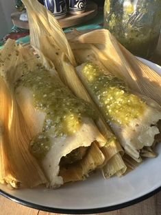 an enchilada on a white plate with sauce