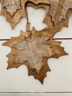 three leaf shaped wooden ornaments hanging on a wall