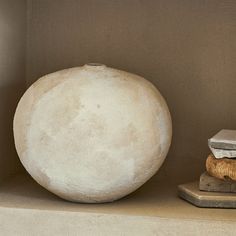 a large white ball sitting on top of a shelf next to a stack of books