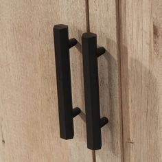 two black handles on a wooden door