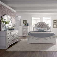 a large white bed sitting in a bedroom on top of a hard wood floor