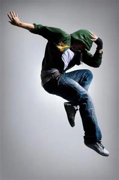 a man flying through the air while riding a skateboard in front of a gray background