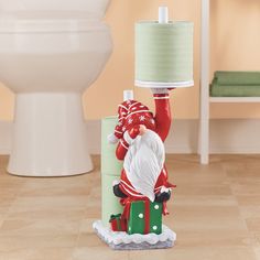 a santa clause figurine holding a lamp on top of a toilet in a bathroom