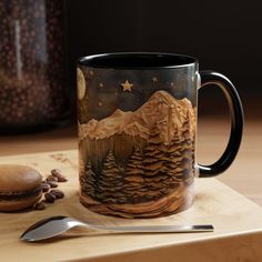 a coffee mug sitting on top of a wooden table next to a spoon and cookie