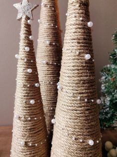 three small christmas trees made out of jute and twine with stars on top