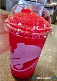 a plastic cup filled with red liquid on top of a counter