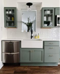 a kitchen with green cabinets and white walls