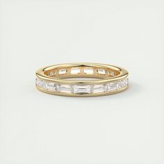 a yellow gold wedding band with baguettes on the side and sides in white diamonds