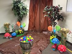 an office decorated for easter with candy and decorations on the floor, potted plants