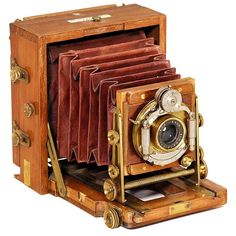 an old fashioned wooden camera with leather cases on it's sides and the lens opened