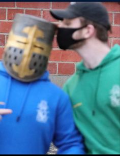 two men wearing masks standing next to each other