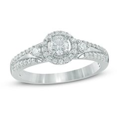 a white gold ring with diamonds on the band and an oval center stone in the middle