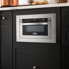 an oven built into the side of a kitchen counter with pots and pans on it