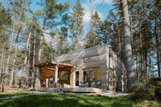 a small wooden cabin in the woods surrounded by trees