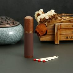 two matches are on the table next to a wooden box with dried flowers and other items