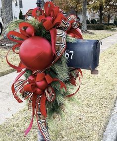 a mailbox decorated with christmas decorations and ribbon tied around the front door to give it a holiday feel