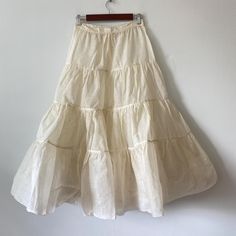 Ivory color 4-tier petticoat with one button and two snaps. Unsure of age. Has a couple small spots but no tears 26" waist 35-1/2" length Fitted Vintage Cream Petticoat, Fitted Cream Petticoat With Ruffles, Vintage Tiered Skirt In Cream, Vintage Cream Tiered Skirt, Spring Cream Petticoat With Ruffles, Cream Tiered Gathered Skirt, Vintage White Tiered Skirt, Spring Wedding Cream Petticoat, Vintage Tiered Skirt Petticoat For Spring