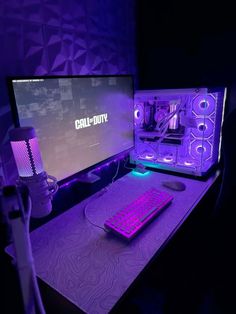 two computer monitors sitting on top of a desk next to a purple keyboard and mouse