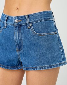 These mini denim shorts feature a mid rise fit, pockets and belt loops. Mid-rise Denim Shorts With Belt Loops, Trendy Short Jean Shorts With Belt Loops, Trendy Mid-rise Shorts With Belt Loops, Mid-rise Medium Wash Jean Shorts With Belt Loops, Mid-rise Denim Blue Jean Shorts With Belt Loops, Mid-rise Medium Wash Shorts With Belt Loops, Trendy Cutoff Shorts With Belt Loops, Mini Length Shorts With Pockets In Medium Wash, Trendy Dark Wash Mini Length Shorts