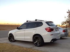 a white bmw suv parked on the side of the road