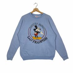 a blue sweatshirt with mickey mouse on the front and an image of a cartoon character