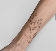 a person's arm with a flower tattoo on the left side of their arm