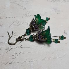 EMERALD FLOWER EARRINGS  ▪️▪️▪️▪️▪️▪️▪️️▪️▪️▪️▪️▪️▪️ These pretty emerald green floral earrings are made with super cute Lucite fairy flowers which have been hand painted with an iridescent finish. They have Swarovski crystals in beautiful emerald green added for sparkle when they move and are finished with fish hook ear wires and ornate floral bead caps. They are very light weight and are perfect for special occasions, festivals and bridesmaids yet cute enough for everyday wear.  💜A matching p Vintage Inspired Earrings, Gothic Earrings, Steampunk Accessories, Vintage Inspired Jewelry, Hippie Earrings, Motif Vintage, Bridesmaid Accessories, Floral Pendant, Earrings Flower