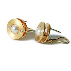 Gold & Pearl Earrings - This modern pearl earring exemplifies industrial aesthetics through minimalist design. The top metal discs are finished with a circular pattern for an industrial vibe, with two telescoping tube rivets securing the discs and 7 mm, white Akoya pearls mounted at the center. 18K omega earring findings on the backs of the earrings make for easy wear. Modern Pearl Earrings For Formal Occasions, Modern Gold Pearl Earrings, Modern Round Pearl Earrings, Modern Metal Pearl Earrings For Pierced Ears, Modern Metal Pearl Earrings, Modern Pearl Drop Earrings, Rivet Jewelry, Modern Pearl Earrings, Gold Fronts