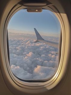 an airplane window looking out at the clouds