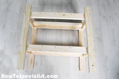 a wooden step stool sitting on top of a hard wood floor