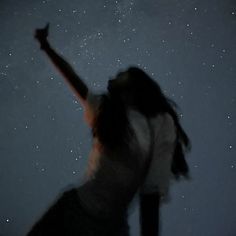 a woman is reaching up to the sky with her arm in the air and stars above