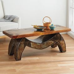 a wooden table sitting on top of a hard wood floor next to a white couch