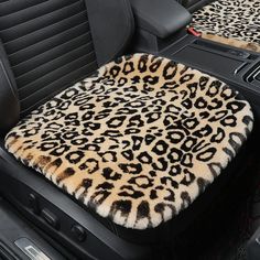 a leopard print car seat cover in the back of a car with black leather seats