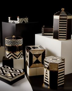 an assortment of black and white boxes with gold trimmings on the sides, sitting on top of each other