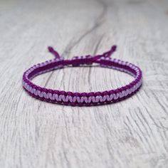 a purple string bracelet with hearts on it