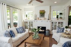 a living room with couches, chairs and a fire place in the middle of it