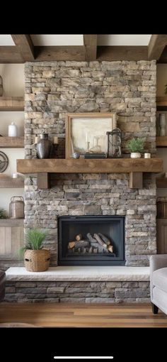 a living room with a stone fireplace and wooden shelves