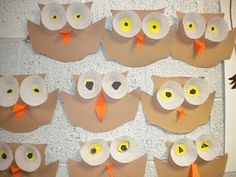 an owl themed bulletin board with lots of paper owls on it's sides and yellow eyes